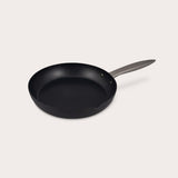 The Zyliss Ultimate Pro Non-Stick Frying Pan With Pouring Lip, made of hard-anodized aluminium with a metal handle, sits on a plain white background, viewed at a slight angle. #24cm/9½"