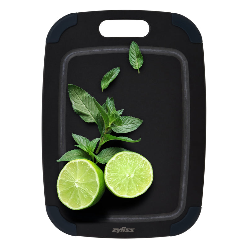 A Zyliss Wood Fibre Cutting Board in black, topped with two lime halves and fresh mint leaves—an eco-friendly board made from recycled wood fibres. #Small
