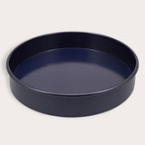 A round, dark Zyliss Durable Non-Stick Removable Base Cake Pan with high sides sits on a light surface, empty. Its smooth nonstick interior ensures easy release and effortless cleanup.