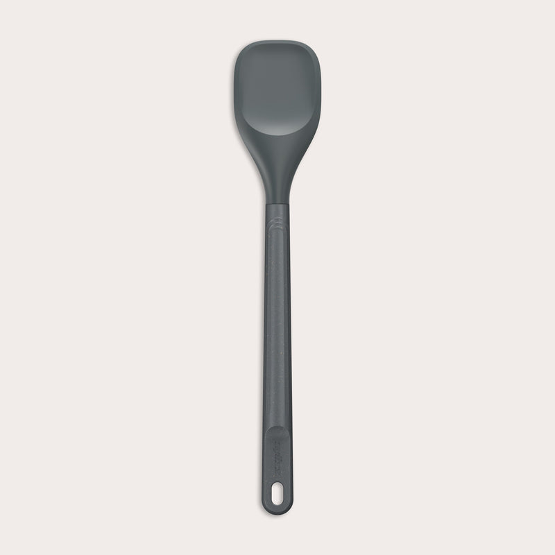 #medium The Zyliss Spoontula is dark gray, with a silicone head, long ergonomic handle, and a gently rounded rectangular bowl, pictured on a plain light background. #Medium