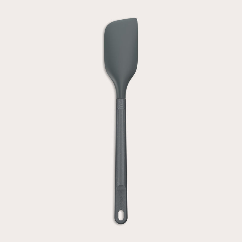 A dark gray Zyliss Spatula with a silicone head, curved flexible blade, and long handle with a hanging hole is shown on a plain light background. #Medium
