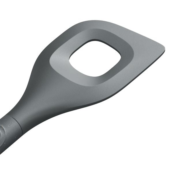 A close-up of a gray kitchen utensil with a flat, angled head and a large square hole in the center, designed for stirring or serving food.