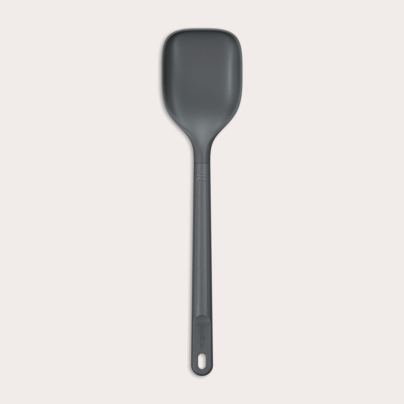#large A durable Zyliss Spoon in dark gray silicone, featuring a long handle with a hole at the end, displayed on a plain light background. #Large
