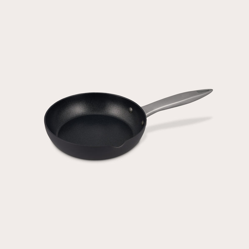 The Zyliss Ultimate Pro Non-Stick Frying Pan With Pouring Lip features a black, Swiss-coated hard-anodized aluminum body and a long gray handle, shown on a plain white background. #20cm/8"
