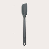 The Zyliss Spatula, featuring a long handle and flat, angled grey silicone head, is displayed against a plain white background.