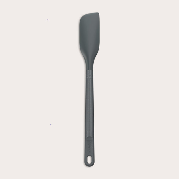 The Zyliss Spatula, featuring a long handle and flat, angled grey silicone head, is displayed against a plain white background.